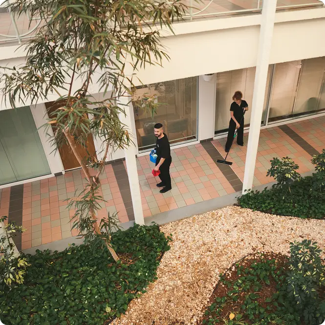 Overhead view of Anago cleaning professionals cleaning an office courtyard walkway